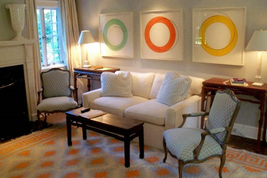 Imagen de sala de estar con biblioteca cerrada contemporánea grande con paredes beige, suelo de madera en tonos medios, todas las chimeneas y marco de chimenea de piedra