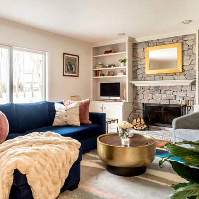 Transitional enclosed medium tone wood floor and brown floor family room photo in New York with white walls, a standard fireplace, a stone fireplace and a media wall