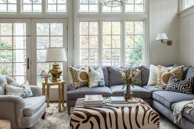 Diseño de sala de estar abierta clásica renovada grande sin chimenea y televisor con paredes beige, suelo de madera en tonos medios y suelo marrón