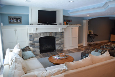 Idées déco pour une salle de séjour classique ouverte avec un mur bleu et un manteau de cheminée en pierre.