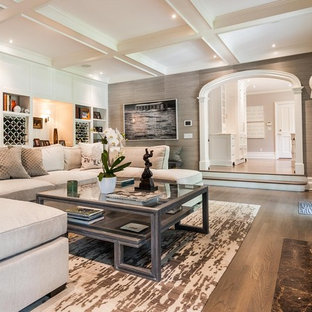 Mittelgroßes, Fernseherloses, Offenes Klassisches Wohnzimmer mit Hausbar, grauer Wandfarbe, braunem Holzboden, Kamin und braunem Boden in New York