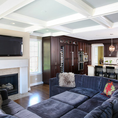 Large elegant open concept dark wood floor family room photo in Chicago with beige walls, a standard fireplace, a wall-mounted tv and a stone fireplace