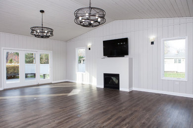 Mid-sized transitional enclosed dark wood floor family room photo in Chicago with gray walls, a standard fireplace, a plaster fireplace and a wall-mounted tv