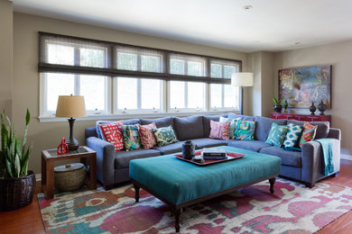 Ejemplo de sala de estar ecléctica grande con paredes beige, suelo de madera en tonos medios y televisor colgado en la pared