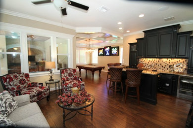 Large traditional open plan games room in Orlando with beige walls, dark hardwood flooring and brown floors.