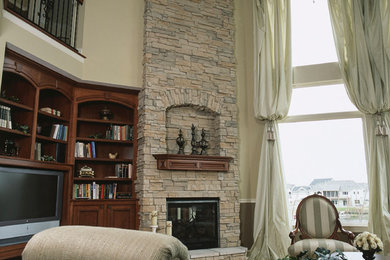Diseño de sala de estar cerrada tradicional grande con paredes beige, suelo de madera oscura, todas las chimeneas, marco de chimenea de piedra y pared multimedia