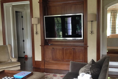 Imagen de sala de estar abierta actual extra grande con paredes beige, suelo de madera oscura y televisor colgado en la pared