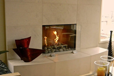 На фото: гостиная комната среднего размера в современном стиле с стандартным камином и фасадом камина из камня с
