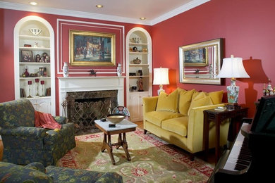 Foto de sala de estar con rincón musical cerrada tradicional de tamaño medio con todas las chimeneas, marco de chimenea de piedra, paredes rojas y suelo de madera clara