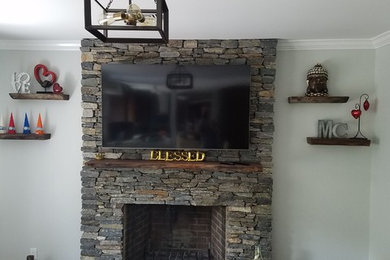 Mid-sized elegant open concept dark wood floor and brown floor family room photo in New York with a standard fireplace, a stone fireplace and a wall-mounted tv