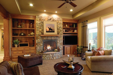 Inspiration for a large craftsman enclosed carpeted family room remodel in Boston with beige walls, a standard fireplace, a stone fireplace and a media wall