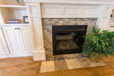 Example of a transitional family room design in Raleigh with a standard fireplace and a stone fireplace