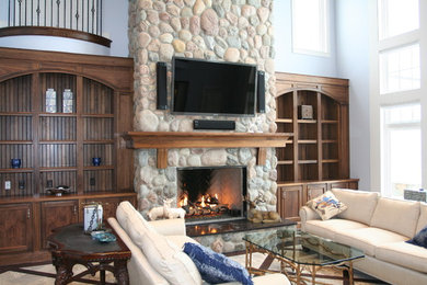 Foto de sala de estar abierta rural extra grande con paredes azules, suelo de madera oscura, todas las chimeneas, marco de chimenea de piedra y televisor colgado en la pared