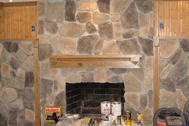 Example of a mountain style open concept family room design in Other with a stone fireplace