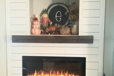 ルイビルにあるカントリー風のおしゃれなファミリールーム (淡色無垢フローリング、コーナー設置型暖炉、木材の暖炉まわり) の写真