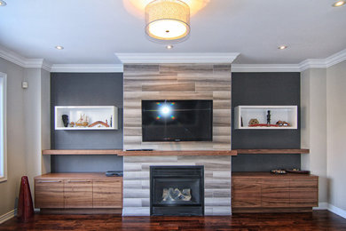 Foto de sala de estar tradicional renovada con paredes grises, suelo de madera oscura, todas las chimeneas, marco de chimenea de baldosas y/o azulejos y pared multimedia