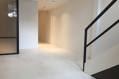 Inspiration pour une salle de séjour minimaliste avec sol en béton ciré et un sol gris.