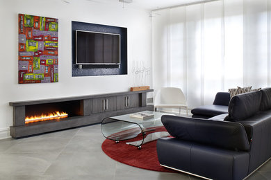 Modelo de sala de estar abierta minimalista de tamaño medio con paredes blancas, suelo de baldosas de porcelana, chimenea lineal, marco de chimenea de hormigón y televisor colgado en la pared
