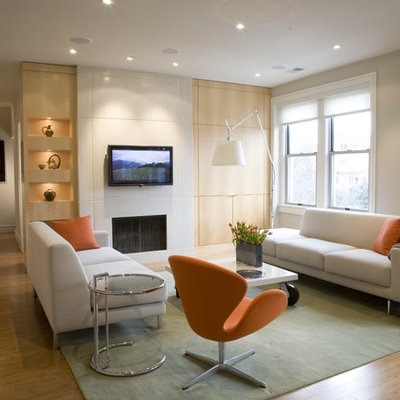 Inspiration for a contemporary medium tone wood floor family room remodel in DC Metro with beige walls, a standard fireplace and a wall-mounted tv