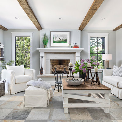 Inspiration for a mid-sized coastal multicolored floor family room remodel in Detroit with gray walls, a standard fireplace, a plaster fireplace and no tv