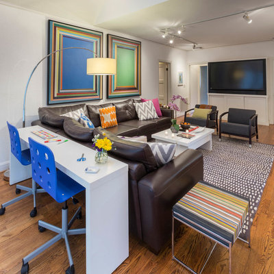 Family room - large eclectic enclosed medium tone wood floor family room idea in Dallas with white walls and a media wall