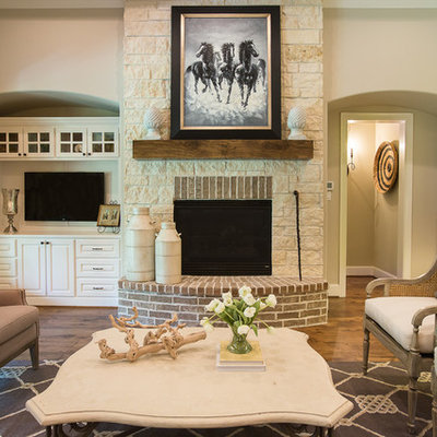 Family room - traditional medium tone wood floor family room idea in Dallas with beige walls, a standard fireplace, a wall-mounted tv and a stone fireplace