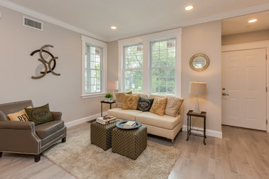 Mittelgroßes, Offenes Klassisches Wohnzimmer ohne Kamin mit beiger Wandfarbe, hellem Holzboden, braunem Boden und TV-Wand in Boston