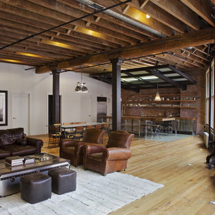 Esempio di un grande soggiorno industriale aperto con pareti multicolore e parquet chiaro