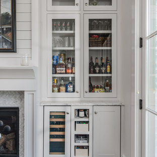 Example of a country dark wood floor family room design in Nashville with a bar, white walls, a standard fireplace, a tile fireplace and no tv