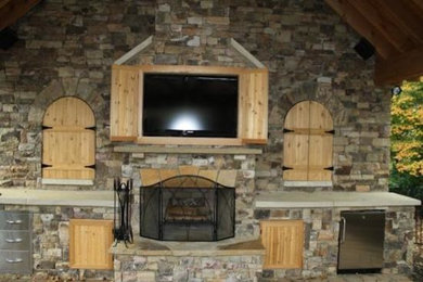 Example of a family room design in Other with a standard fireplace, a stone fireplace and a wall-mounted tv