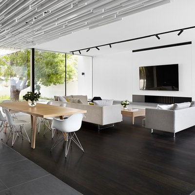 Example of a large trendy open concept dark wood floor family room design in Perth with white walls, a standard fireplace, a plaster fireplace and a wall-mounted tv