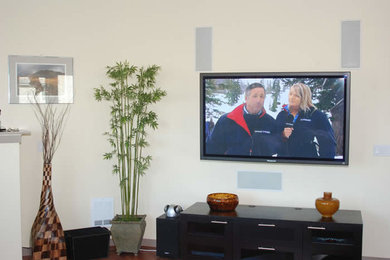 Imagen de sala de estar sin chimenea con paredes beige y televisor colgado en la pared