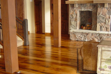 Klassisches Wohnzimmer mit beiger Wandfarbe, braunem Holzboden, Kamin und Kaminumrandung aus Stein in Boise