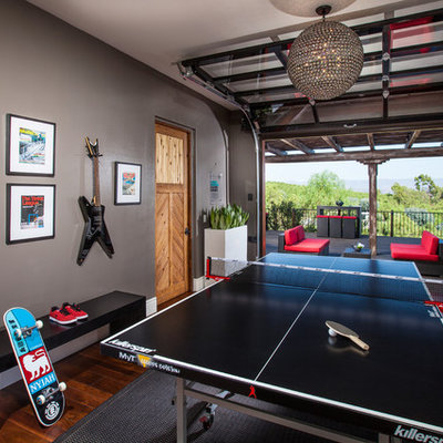 Game room - large contemporary enclosed medium tone wood floor game room idea in Orange County with beige walls, no fireplace and a wall-mounted tv