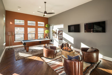 Inspiration for a mid-sized contemporary open concept dark wood floor and brown floor game room remodel in Houston with gray walls and a wall-mounted tv