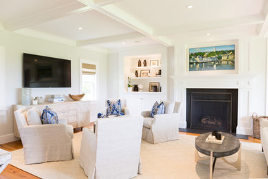 Immagine di un soggiorno costiero di medie dimensioni e aperto con pareti bianche, TV a parete, pavimento marrone, camino classico e soffitto a cassettoni
