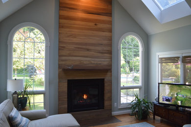 Imagen de sala de estar actual con marco de chimenea de madera