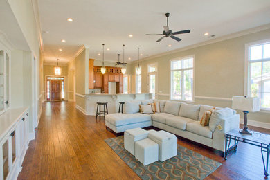 Mid-sized elegant open concept medium tone wood floor family room photo in Charleston with beige walls and no fireplace