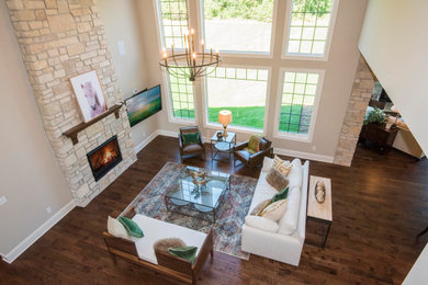Inspiration for a large transitional open concept medium tone wood floor and brown floor family room remodel in Milwaukee with beige walls, a standard fireplace, a stone fireplace and a wall-mounted tv