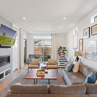Offenes Modernes Wohnzimmer mit weißer Wandfarbe, hellem Holzboden, verputzter Kaminumrandung, braunem Boden, Gaskamin und Wand-TV in Los Angeles