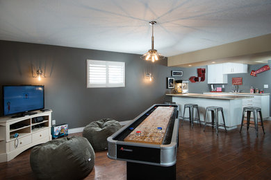 Example of a large urban open concept game room design in Toronto with gray walls and a tv stand
