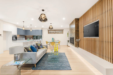 Идея дизайна: открытая гостиная комната среднего размера в современном стиле с светлым паркетным полом, стандартным камином, фасадом камина из плитки и телевизором на стене