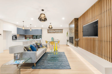 Réalisation d'une salle de séjour design de taille moyenne et ouverte avec parquet clair, une cheminée standard, un manteau de cheminée en carrelage et un téléviseur fixé au mur.