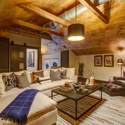 Inspiration for a mid-sized rustic loft-style dark wood floor and brown floor family room remodel in Raleigh with a bar, gray walls, a wall-mounted tv and no fireplace