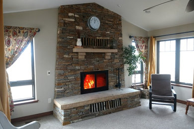 Foto de sala de estar tipo loft de estilo americano grande con estufa de leña y marco de chimenea de piedra