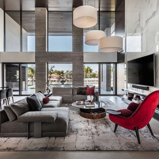 Geräumiges, Offenes Modernes Wohnzimmer mit Porzellan-Bodenfliesen, Wand-TV, weißer Wandfarbe und grauem Boden in Miami