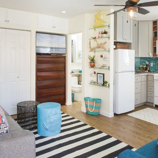 Family room - small coastal open concept vinyl floor and brown floor family room idea in San Diego with white walls and a wall-mounted tv