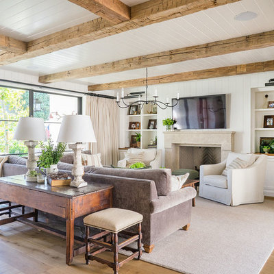 Family room - coastal light wood floor family room idea in Orange County with white walls, a standard fireplace and a wall-mounted tv