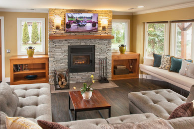 This is an example of a medium sized eclectic open plan games room in Detroit with green walls, dark hardwood flooring, a standard fireplace, a stone fireplace surround and a wall mounted tv.