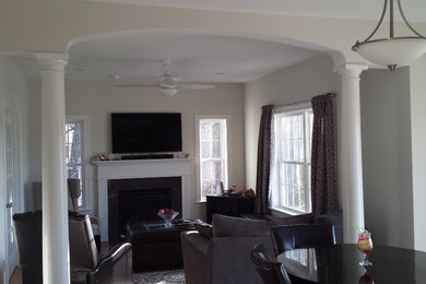 Example of a mid-sized classic open concept medium tone wood floor family room design in Bridgeport with beige walls, a standard fireplace and a wall-mounted tv